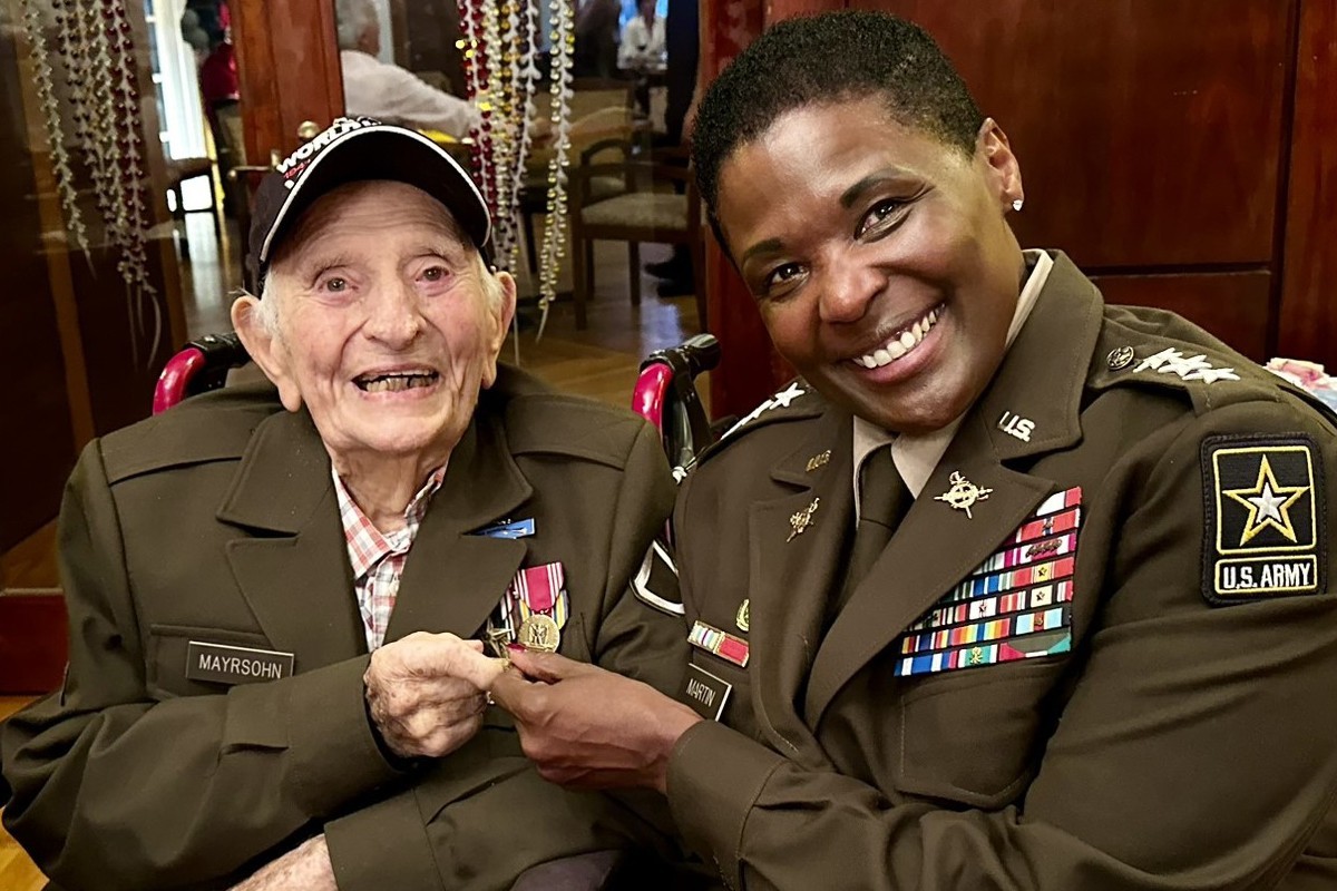 Army veteran Bernard “Barney” Mayrsohn receives a replacement for the jacket he lost 80 years ago